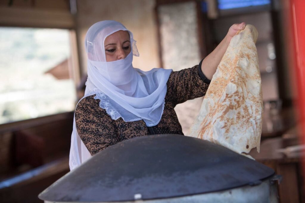 Who are the Druze pople? A Druze woman in a traditional garb baking the pitta