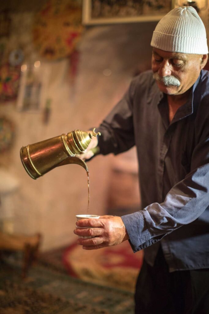 Who are the Druze people? A druze pouring coffee out ot a traditional coffee pot.